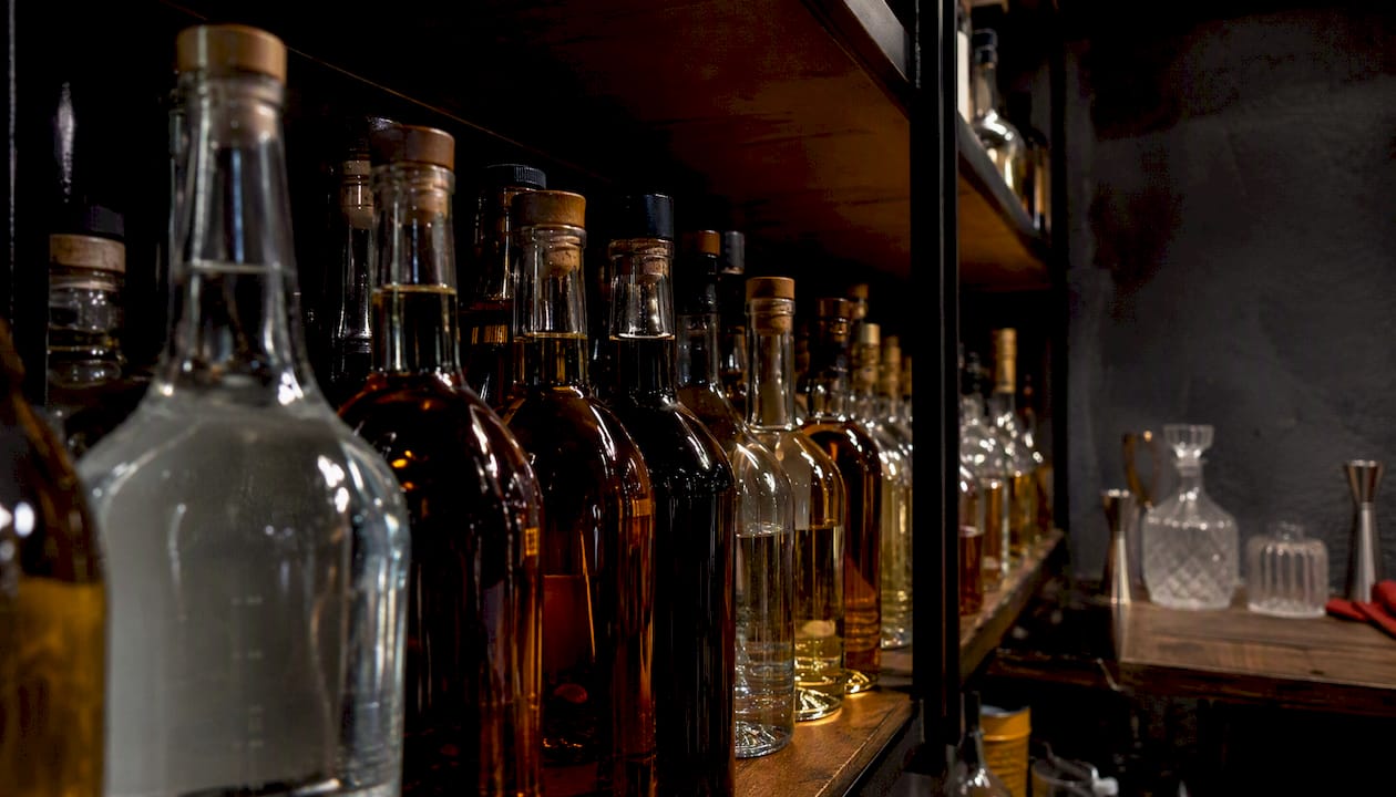 Organized spirits bottles on bar shelf