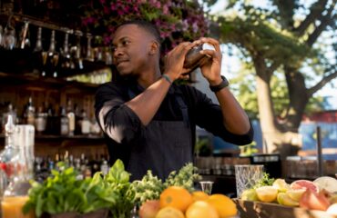Hands shaking a Boston cocktail shaker