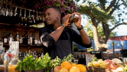 Hands shaking a Boston cocktail shaker