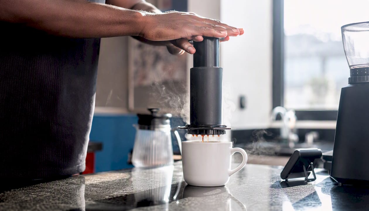 Hand pressing AeroPress plunger during brew